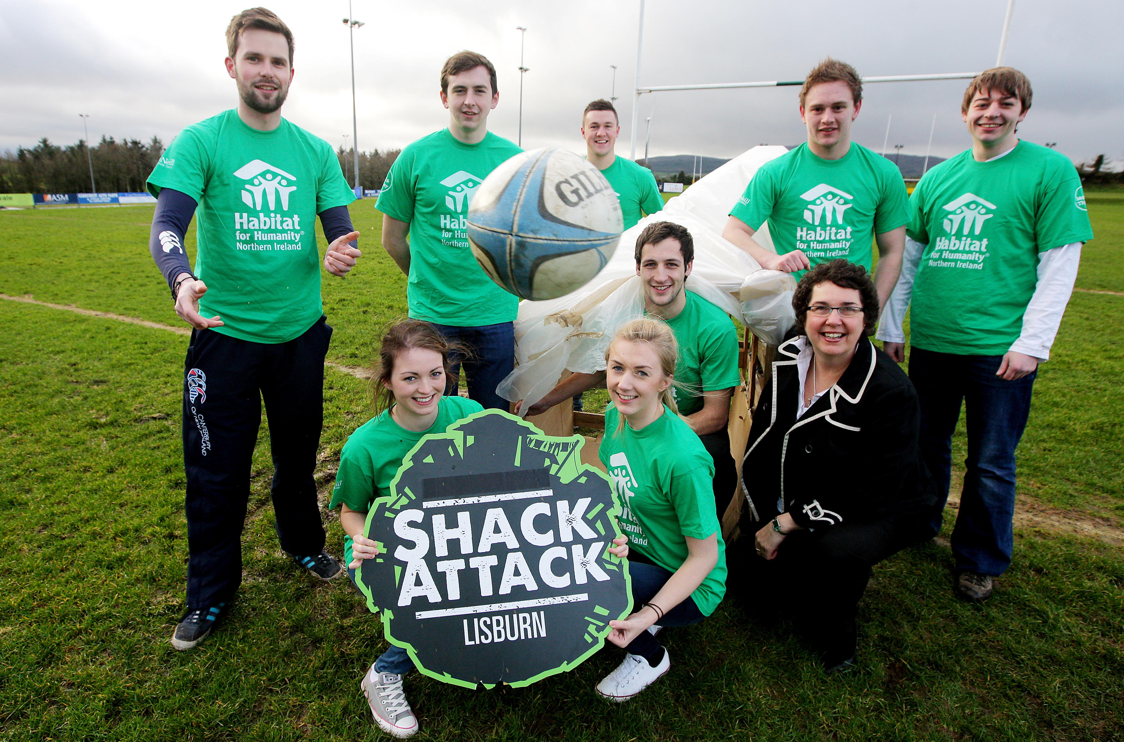 Members of Ballynahinch Rugby Club holding a sign promoting Shack Attack 2014