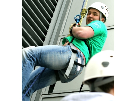 Habitat fundraiser abseiling down a building, smiling to camera